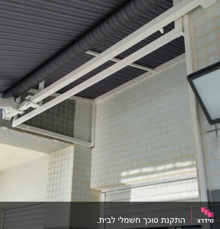 סוכך בד מפוספס מותקן על קיר חיצוני